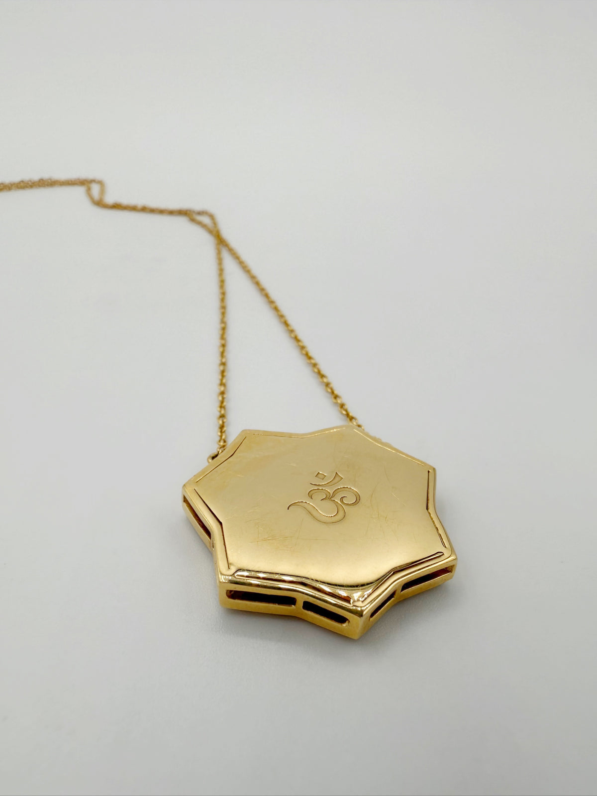 Reverse of ARK OM pendant showing engraved OM symbol in 18K gold