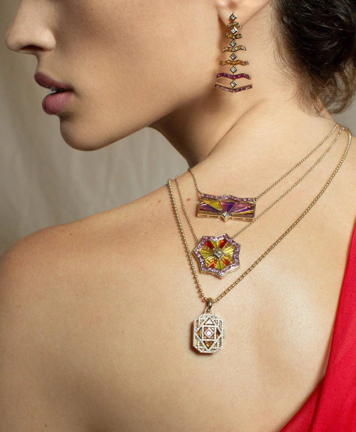 ARK 18K gold OM necklace on model along with other pieces from the Awakenings collection.