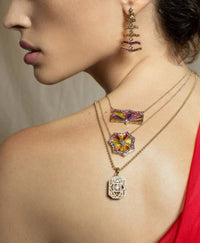 ARK 18K gold OM necklace on model along with other pieces from the Awakenings collection.