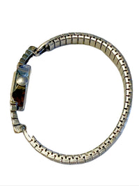 Side view of Art Deco stepped diamond shoulders on 14K white gold Benrus wristwatch and flexible stainless steel bracelet.