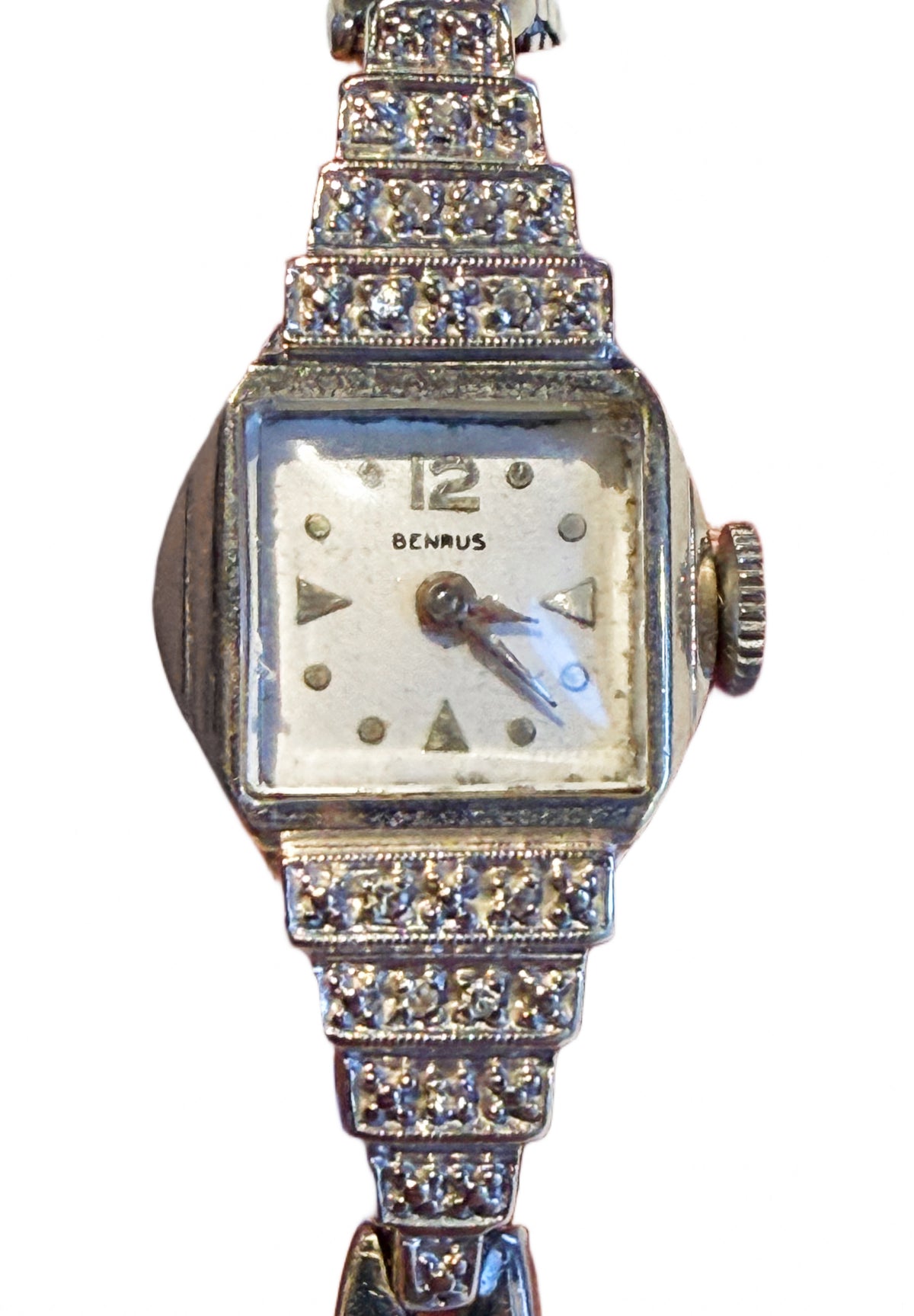 Close-up of 14K white gold Art Deco Benrus watch showing five-tier stepped diamond-set shoulders inspired by skyscraper design.
