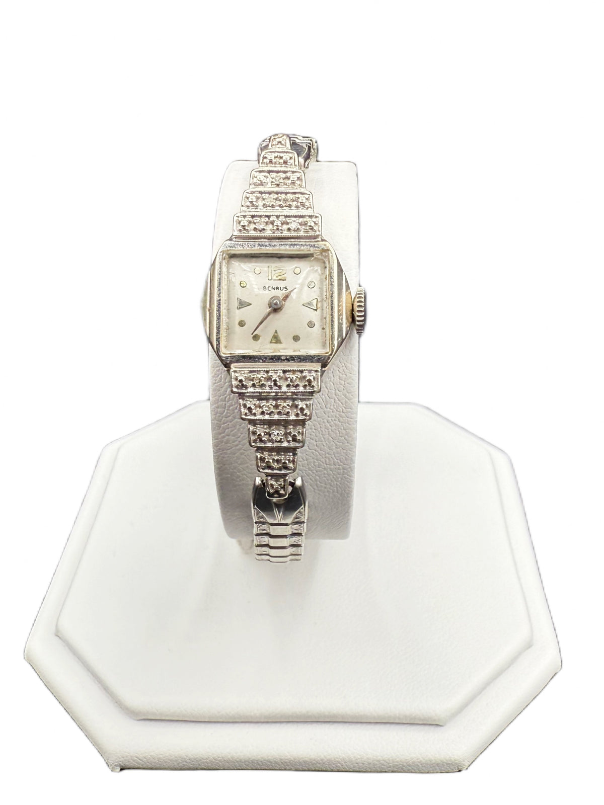 1930s Benrus Art Deco ladies wristwatch in solid 14K white gold with stepped diamond-set shoulders on a watch stand.