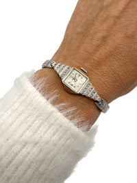 1930s Benrus Art Deco ladies wristwatch in solid 14K white gold with stepped diamond-set shoulders worn on wrist.