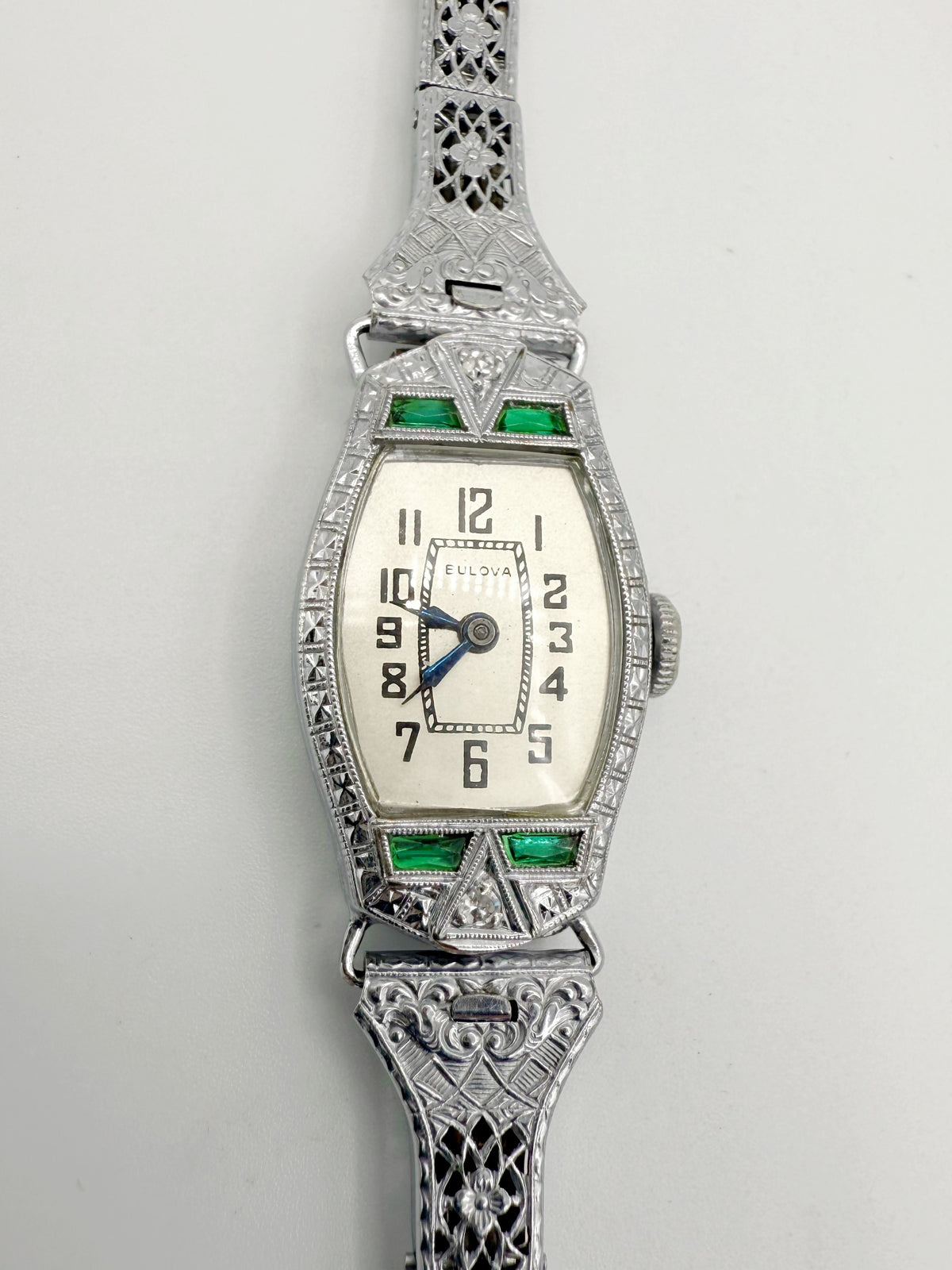 Close-up view; face of 1928 Bulova Art Deco ladies watch in 14K white gold with diamonds and emeralds