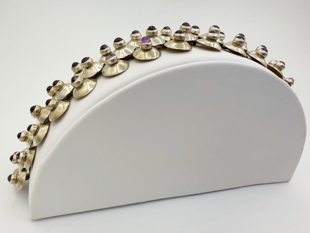 Profile view of domed silver links with amethyst cabochons