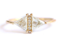 Close-up of Artemer 18k gold geometric ring featuring two triangle diamonds and small accent stones.