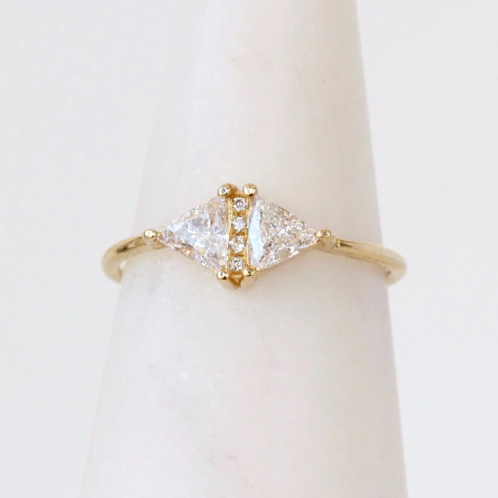 Gold ring with triangular diamond design on a white background