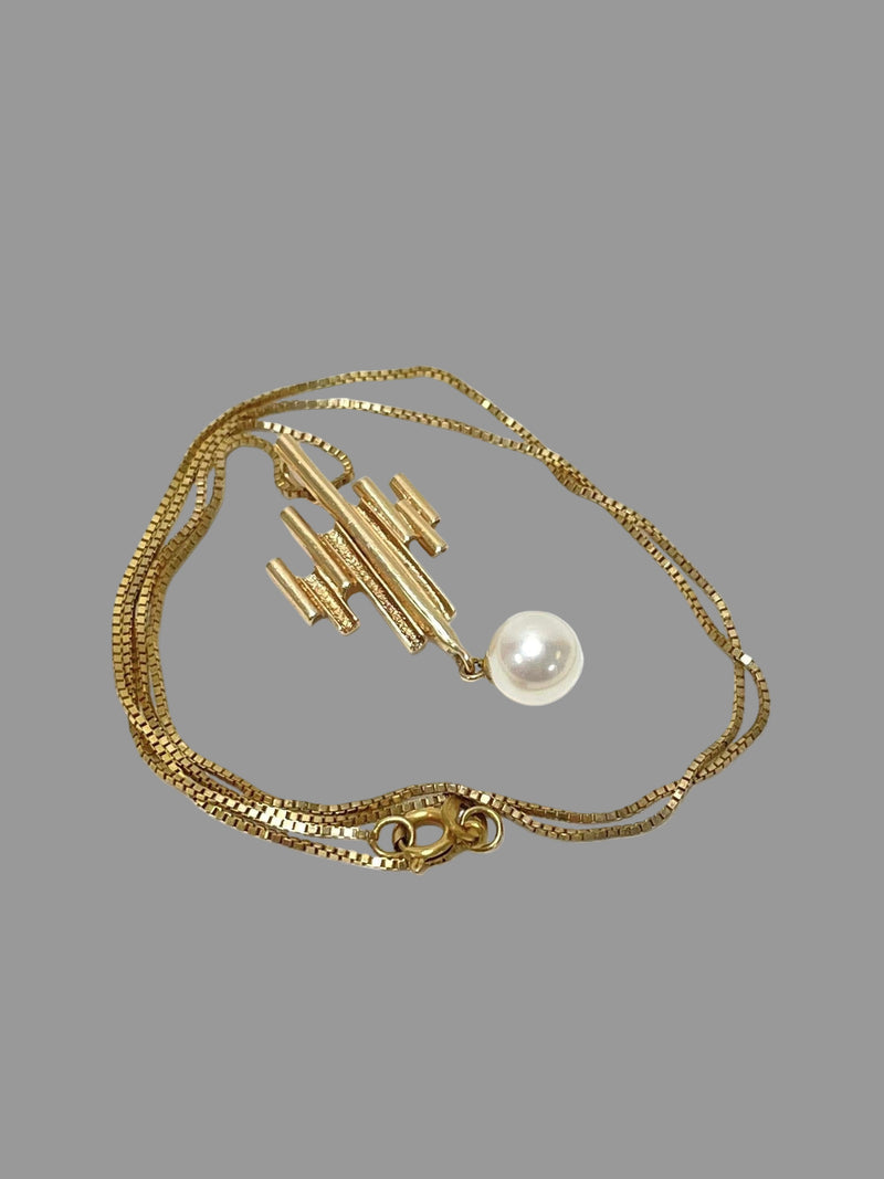 1960s modernist gold pendant necklace featuring geometric bars and a single pearl drop.